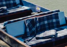 A punt with tartan blankets on the river cam.