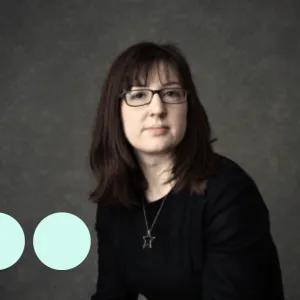 Headshot of woman with dark hair and glasses
