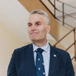 Director of University of Cambridge Professional and Continuing Education, Jim Gazzard, wearing formal clothing, a staircase in the background.