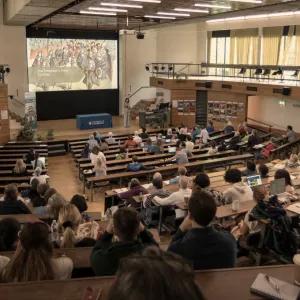 A view from the top of a large lecture theatre full of students. 