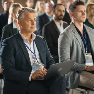 Members of an audience watching and listening to the presenter