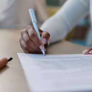 Person sitting at a desk writing a report