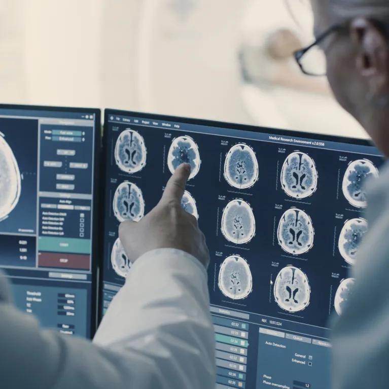 People in white coats studying scans of body
