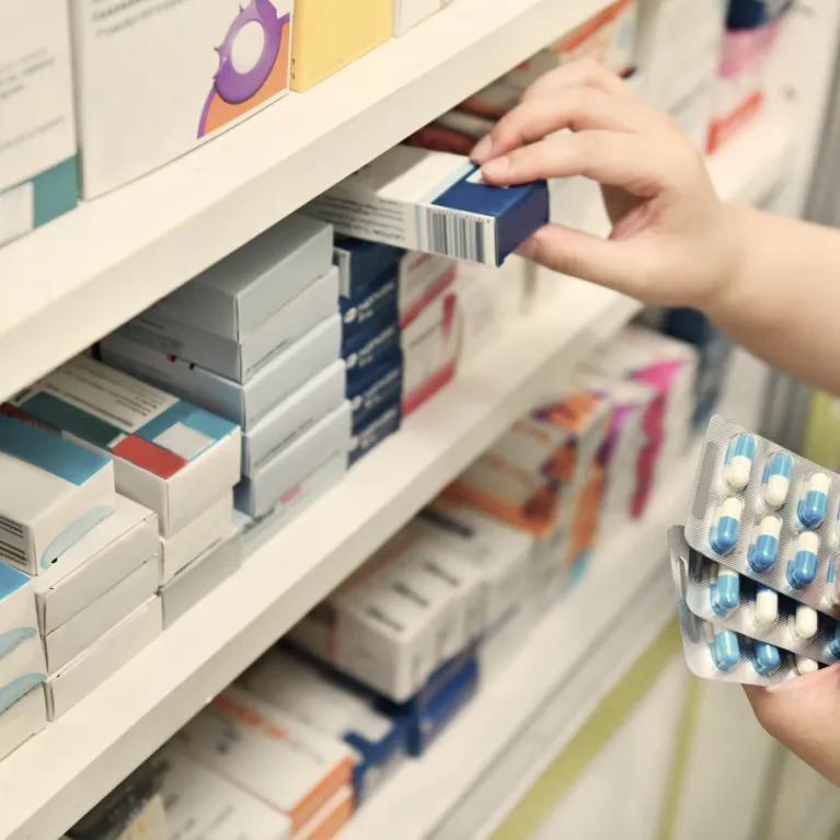 Person checking inventory of pharmacy products