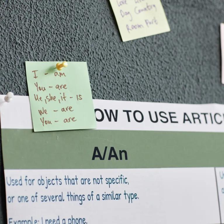 Notes about English grammar displayed on a wall
