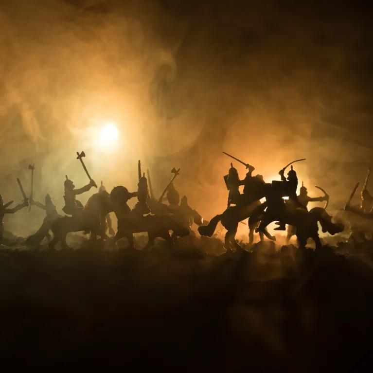 Scene of a battle on horseback with fire in background