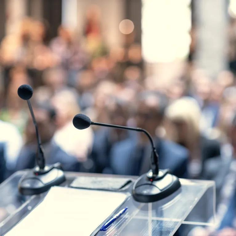 Lectern with microphones and a blurred out audience