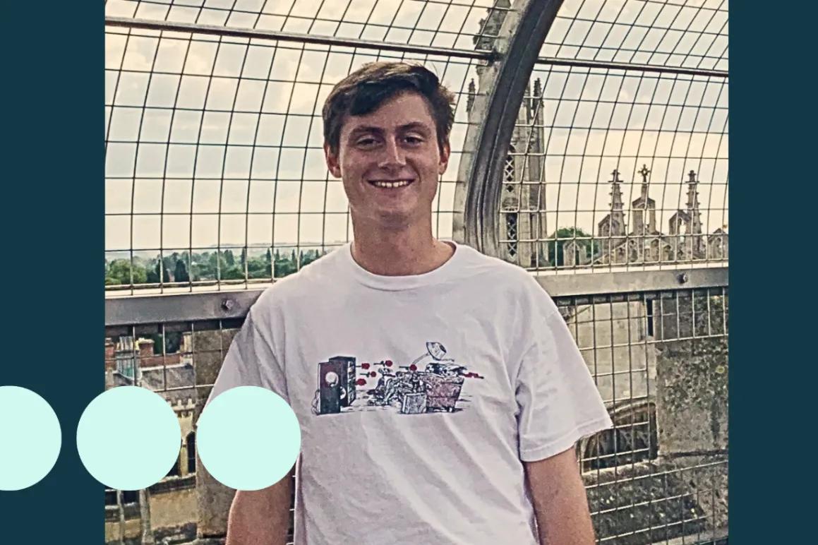 Young man with brown hair smiling for photo